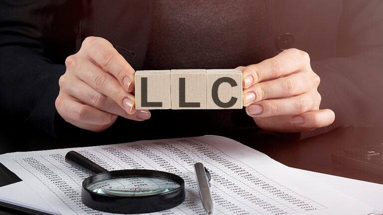 woman holding wooden block with text LLC