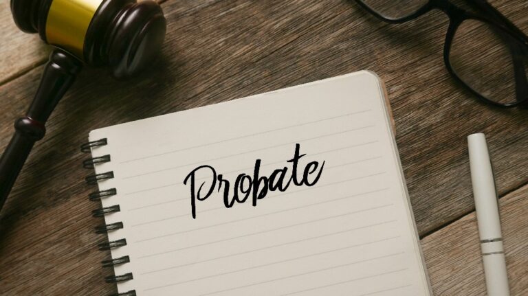 Top view of gavel,glasses,pen and notebook with word Probate