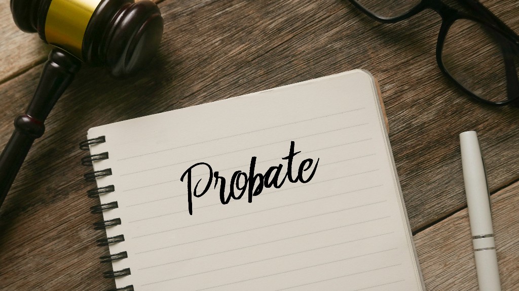 Top view of gavel,glasses,pen and notebook with word Probate